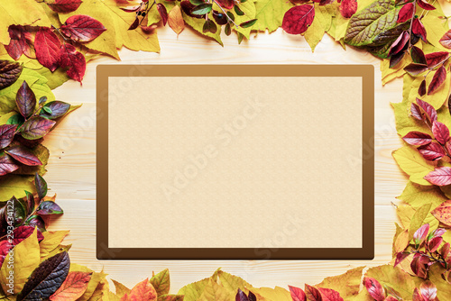 Frame of colorful autumn leaves lying on a wooden table. Template or background for creativity. 