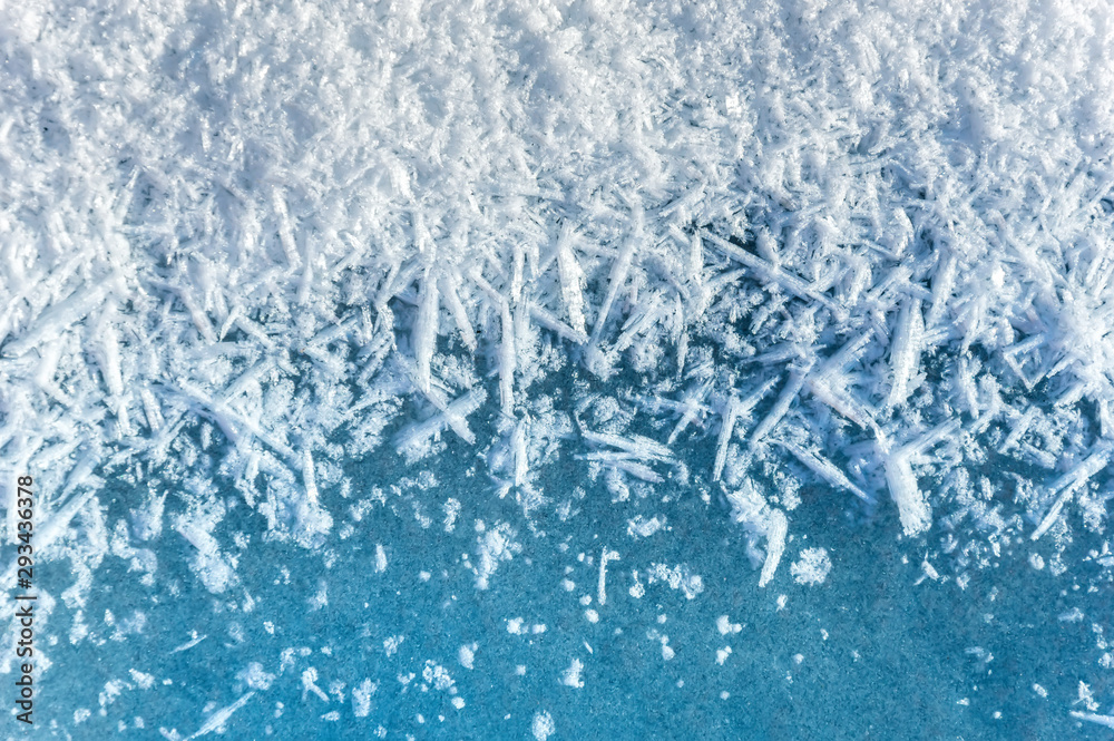 Winter background: close-up of frozen ice with snow crystals and