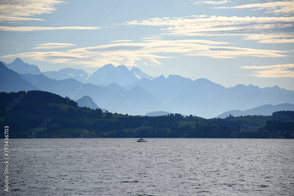 Landscape view of Lake Zug with cirrus clouds and mountains in the distance