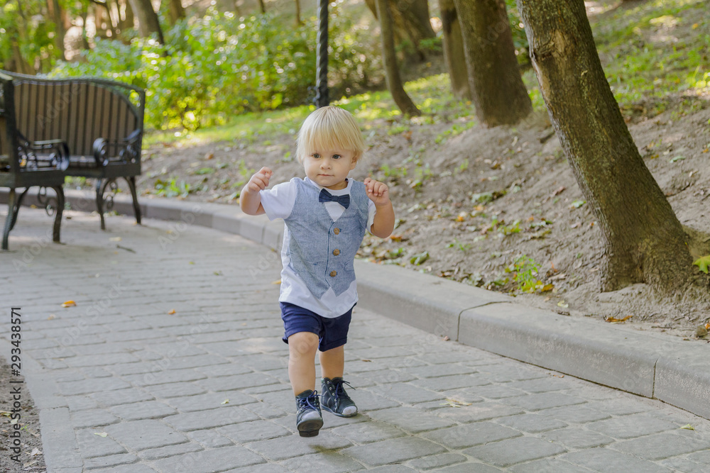 Little boy runs on the asphalt in the park. Little boy runs on the asphalt in the park.