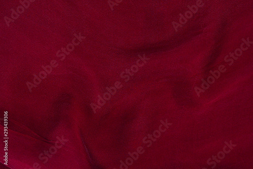 Soft smooth burgundy silk fabric background. Fabric texture. photo