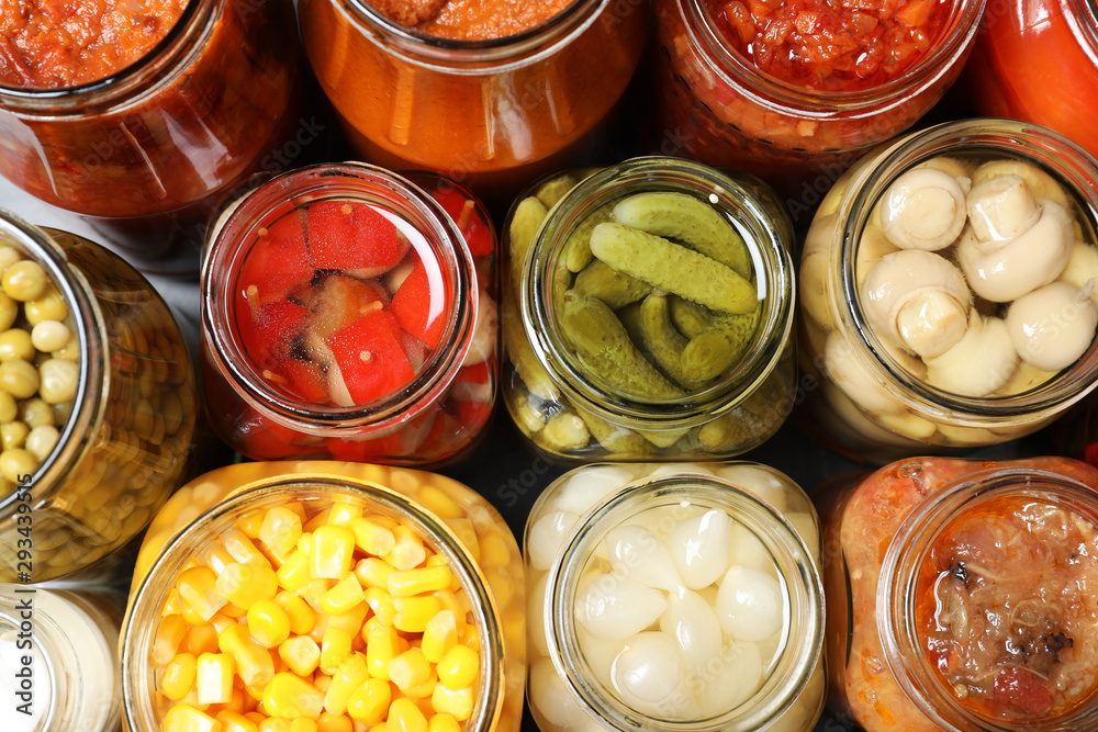Open jars with pickled vegetables on grey table, flat lay Open jars with pickled vegetables on grey table, flat lay