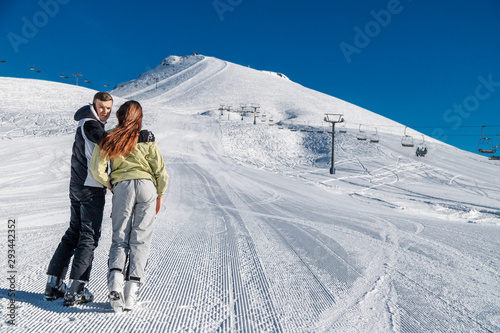 Young happy couple in snowy mountains. Winter sport vacation