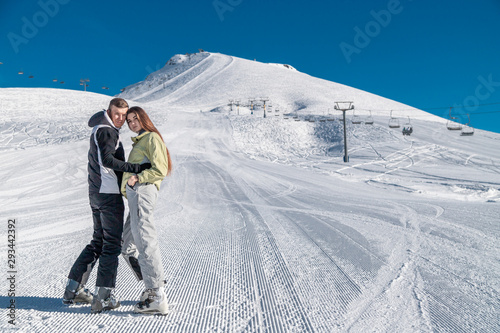 Young happy couple in snowy mountains. Winter sport vacation