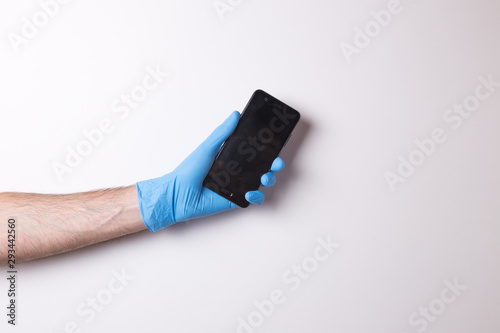 hand in glove, hand holds the phone on white background