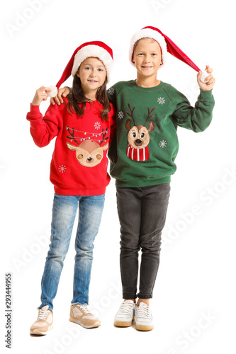 Little children in Christmas sweaters and Santa hats on white background