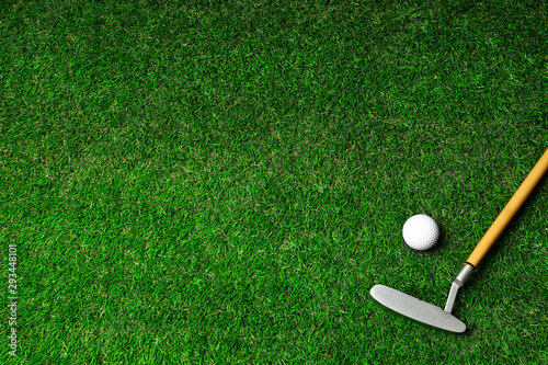 Golf ball and club on green course, flat lay. Space for text