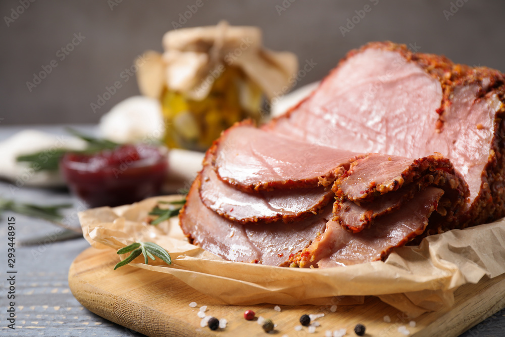 Delicious cooked ham served on wooden board, closeup