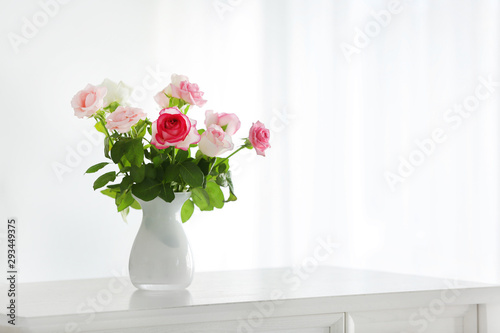 Beautiful rose flowers in vase on table in room