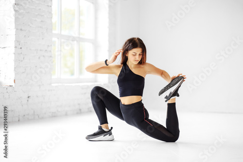 Young athletic girl doing stretching in the gym. The concept of sports, healthy lifestyle, fitness.