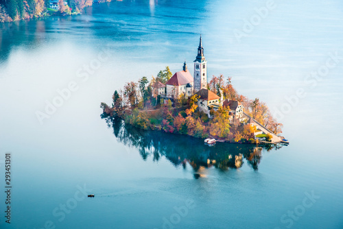 Magical autumn landscape with boat near island on Lake Bled (Blejsko jezero), Julian Alps, Slovenia. Amazing places. Popular tourist atraction. Places of pilgrimage. (Meditation, harmony - concept)