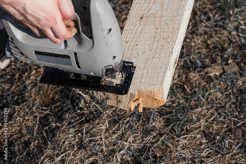 Wallpaper Mural a man saws an electric jigsaw raw Board Torontodigital.ca