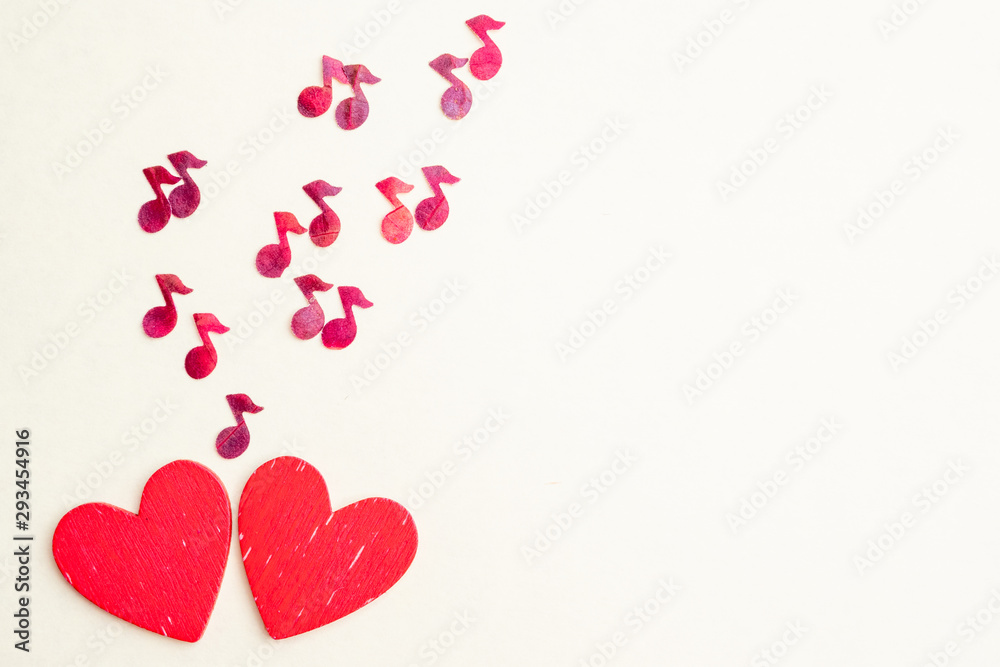 from two wooden hearts fly red notes. The concept of love romantic music