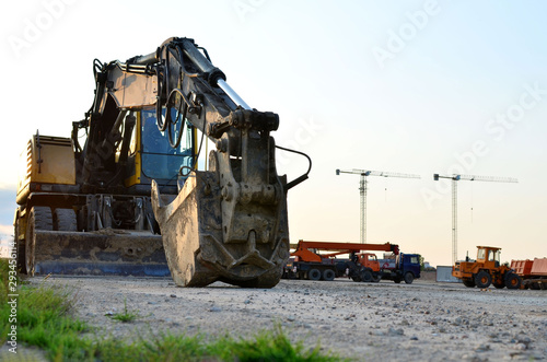 Excavator bucket on the construction site at sunset background and of the blue sky. Land Clearing, grading, pool excavation, utility trenching, utility trenching and foundation digging during photo