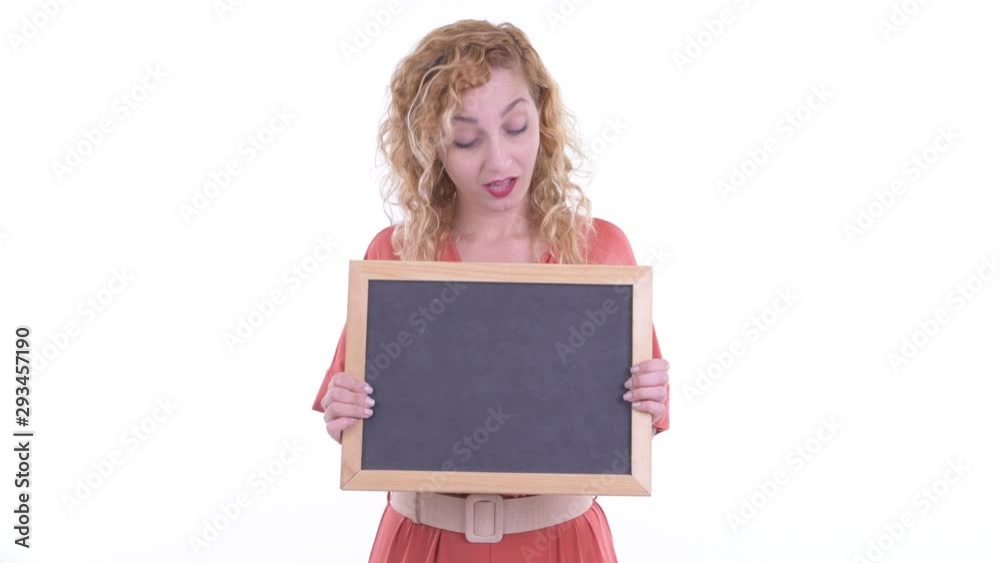 Happy beautiful blonde businesswoman thinking while holding blackboard Happy beautiful blonde businesswoman thinking while holding blackboard