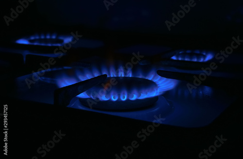 natural butane blue gas burning on kitchen gas stove in dark room