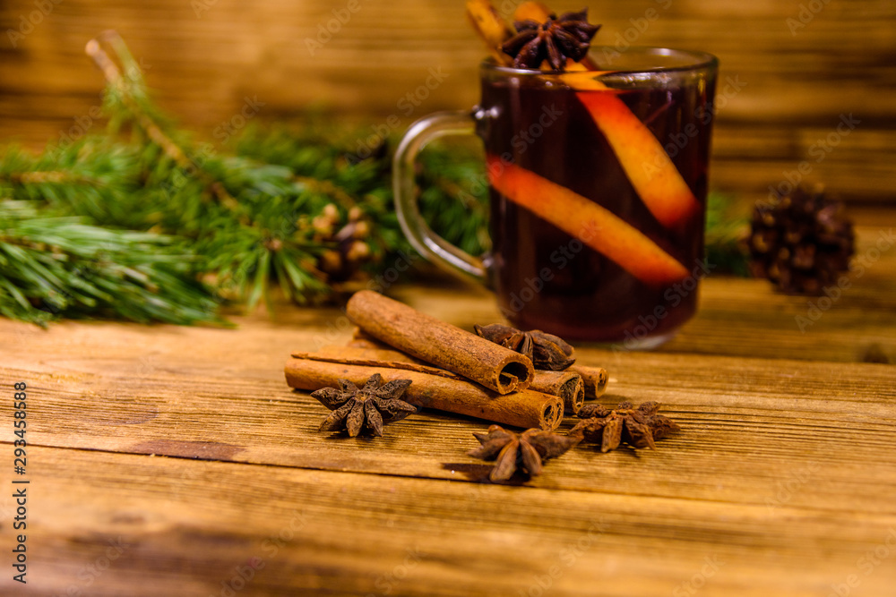 Cup of mulled wine with cinnamon and fir tree branches on wooden table Cup of mulled wine with cinnamon and fir tree branches on wooden table