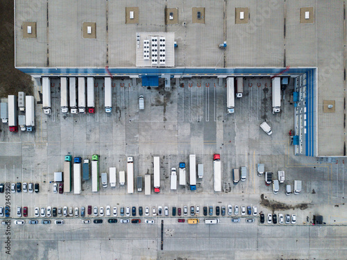 4k Aerial shot of trucks on warehouse parking terminal.