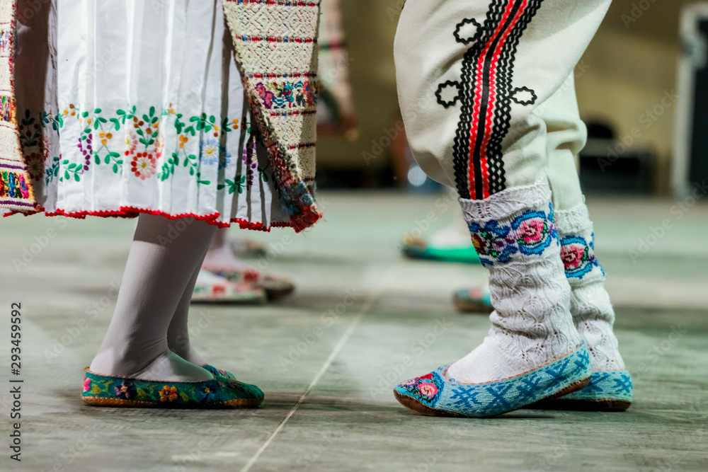 Close up of wool socks on legs of young Romanian female and male dancers in traditional folkloric costume. Folklore of Romania