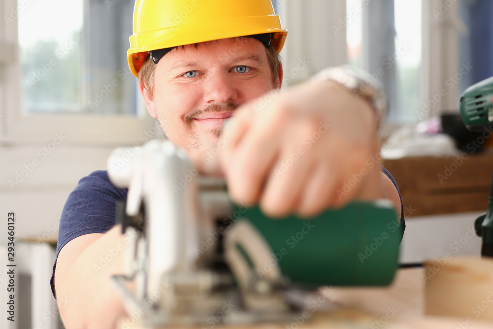 Worker using electric saw portrait. Manual job workplace DIY inspiration improvement fix shop yellow helmet hard hat joinery startup idea industrial education profession career concept Worker using electric saw portrait. Manual job workplace DIY inspiration improvement fix shop yellow helmet hard hat joinery startup idea industrial education profession career concept
