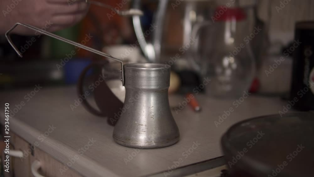 Close-up shot of female hands pouring sugar into an aluminum cezve, process of brewing ground coffee beans at home. Close-up shot of female hands pouring sugar into an aluminum cezve, process of brewing ground coffee beans at home.