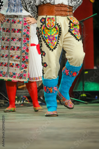 Close up of blue wool socks on legs of young Romanian dancer in traditional folkloric costume. Folklore of Romania