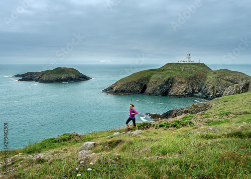 UK, Pembrokeshire, Strumble head, mature, woman running the coast path photo