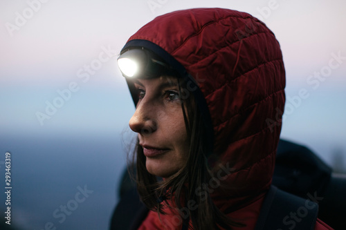 Female hiker wearing headlamp at twilight photo