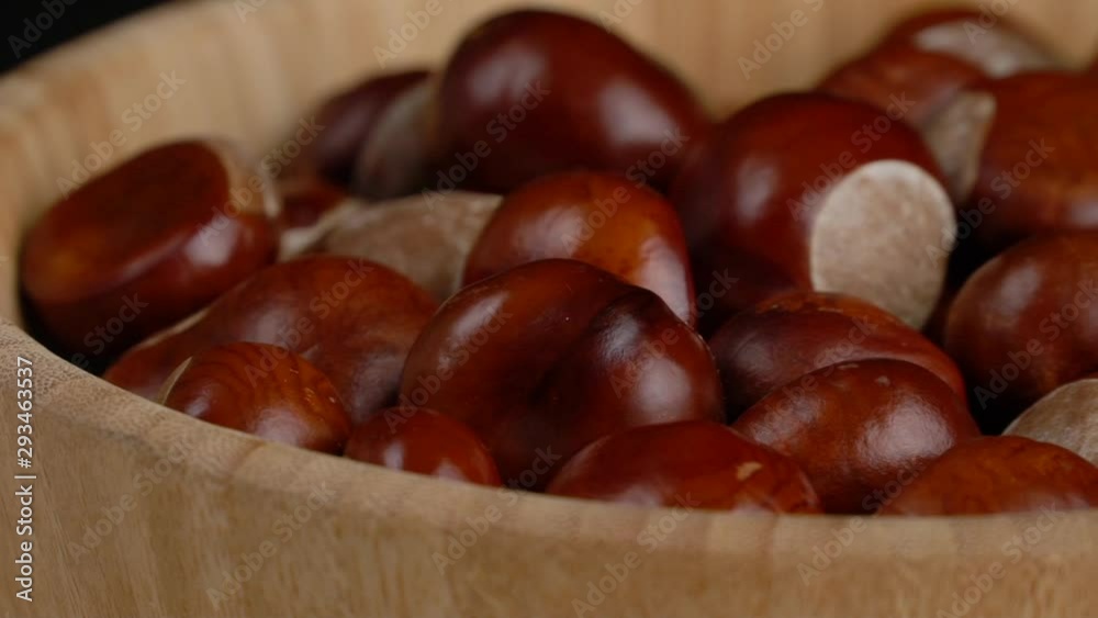 chestnuts in a wooden bowl rotate on black background chestnuts in a wooden bowl rotate on black background