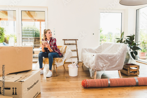 Woman moving into new home using tablet photo