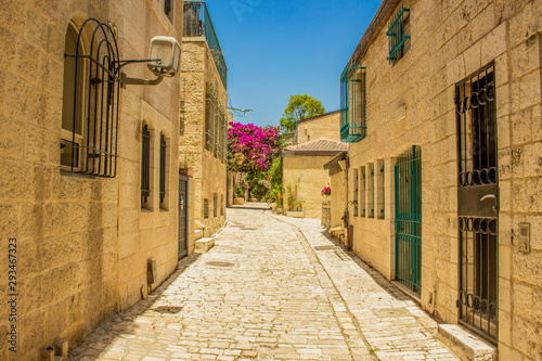Jerusalem old city street empty passage between stone buildings in summer colorful day time 