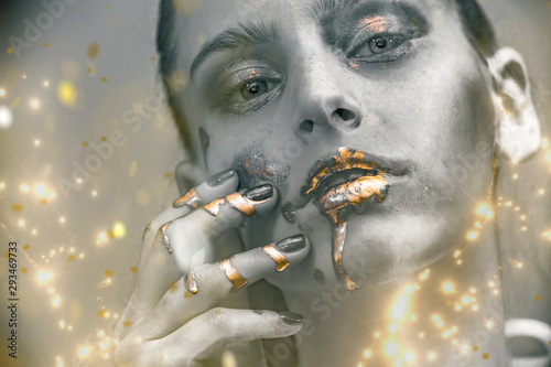 Fototapeta Naklejka Na Ścianę i Meble -  Gold Paint smudges drips from woman face, lips and hand, lipgloss   dripping from sexy lips, golden liquid drops on beautiful model girl's   mouth, gold metallic skin make-up