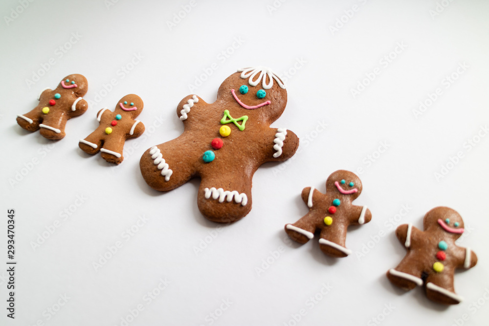 Obraz premium Different sizes of Gingerbread men cookies isolated on white background. Christmas tradition. Top view.