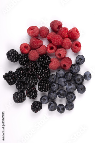 Top view on freshly harvested shiny blackberries, blueberries and raspberries