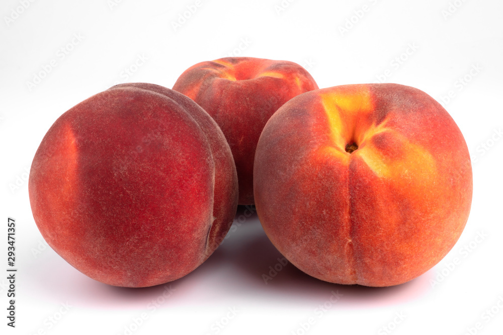 Three red orange freshly collected peaches laying next to each other on white background Three red orange freshly collected peaches laying next to each other on white background