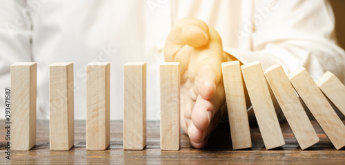 Cuadro en lienzo Businessman stops domino falling