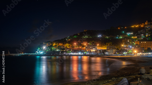 Recco, Genoa, Italy. Wide view of the city of the Ligurian Riviera at night. In the foreground the reflections of the lights of the city on the sea. © Emanuele