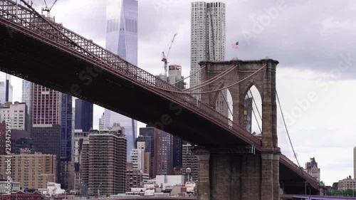Glide moving shot of Brooklyn Bridge towers over the Hudson River in New York City, USA