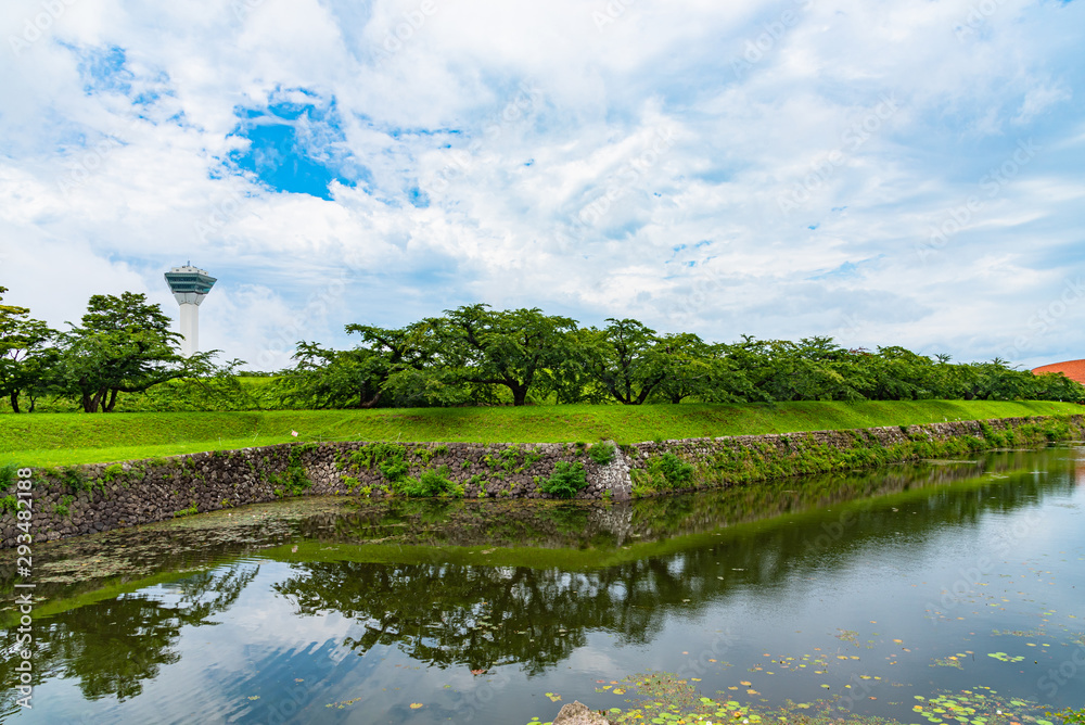 Fototapeta premium Goryokaku Tower in summer sunny day white clouds and bule sky. The tower observatory decks command the entire view of Goryokaku Park, the beautiful star shaped fort. Hakodate City, Hokkaido, Japan