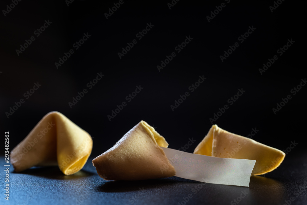 Lucky cookies broken with message of fortune, isolated on black background with empty space for text. Lucky cookies broken with message of fortune, isolated on black background with empty space for text.