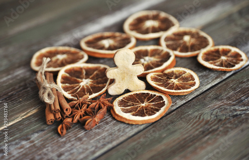 Christmas cookies, cinnamon, dried oranges on wooden background.