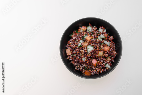 Cooked Sorghum (also known as sorgo) salad or couscous in a back bowl, isolated