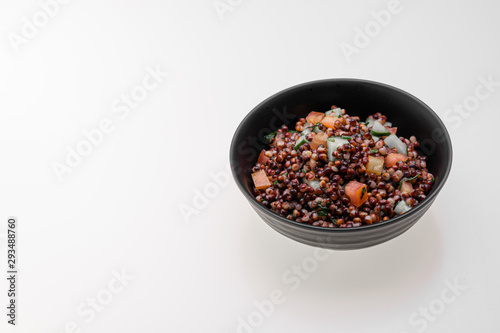 Cooked Sorghum (also known as sorgo) salad or couscous in a back bowl, isolated