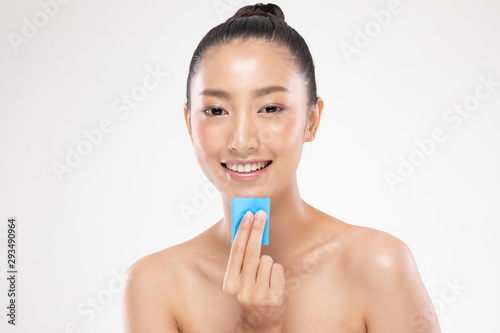 Beautiful Attractive Asian woman using Facial oil clean film to removal oily on face for face fresh skin feeling so fresh and clean,Beauty Concept,Isolated on grey background