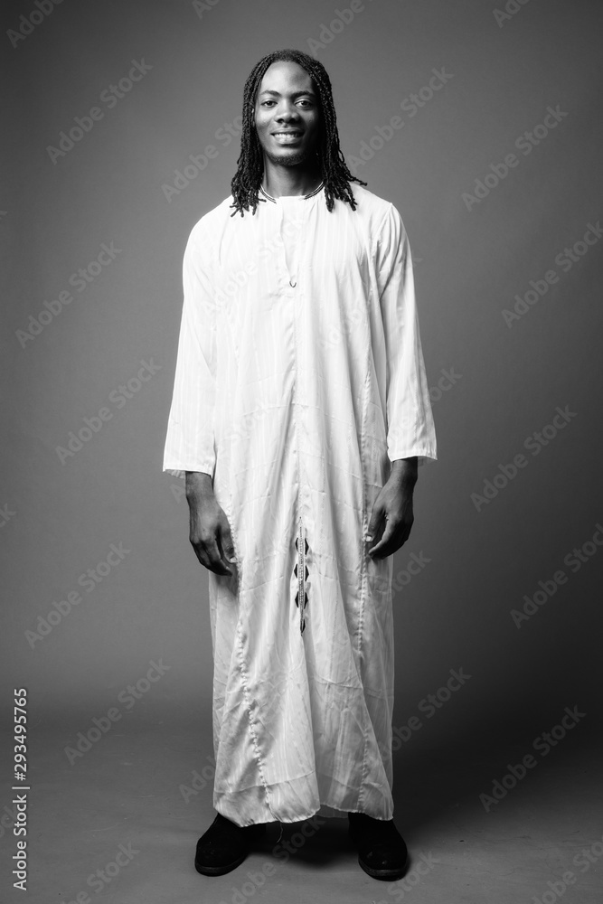 Young handsome African man wearing traditional clothes in black and white