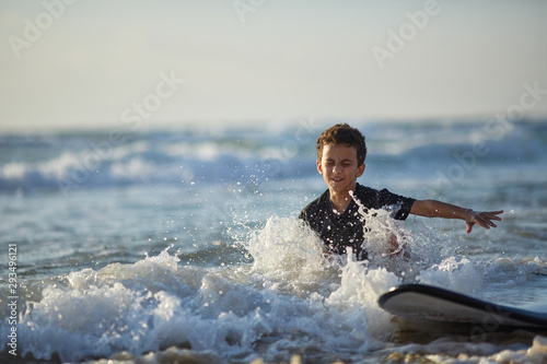Photography boy falls from a surfboard into the water, riding lessons on the waves, children