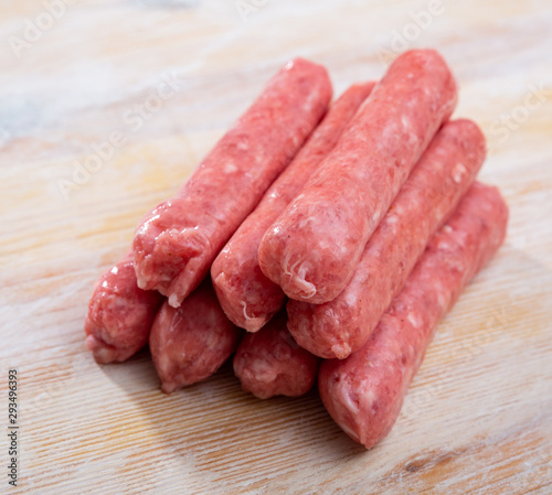 Uncooked sausages on wooden table