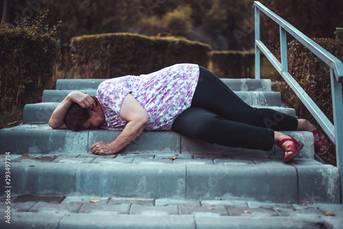 Injured senior woman fallen on the stairs outdoors
