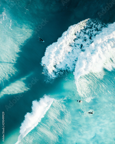 Surfers enjoying massive waves at sunrise in the ocean. Beautiful conditions and spot for a morning surf competition to keep fit and healthy photo