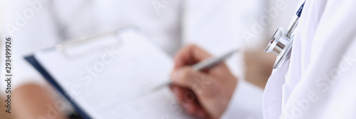 Obraz na płótnie Male doctor hand hold silver pen and showing pad. Physical agreement form signature disease prevention ward round reception consent contract sign prescribe remedy healthy lifestyle concept w salonie